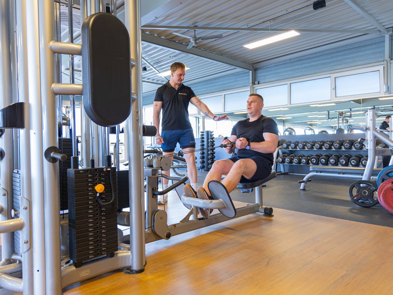 Coach corrigeert techniek bij een sporter in de zaal